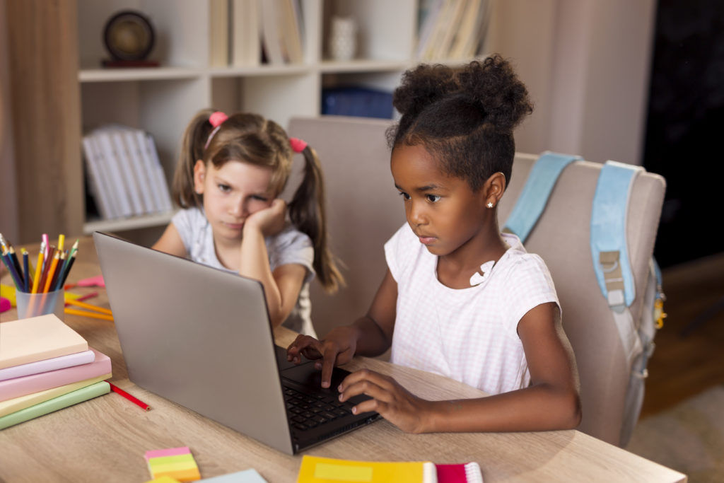 Little girls doing homework on a laptop computer