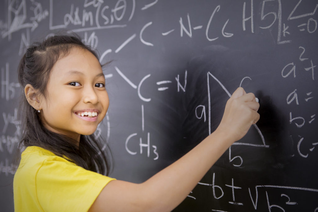 Happy female student writes mathematical formula
