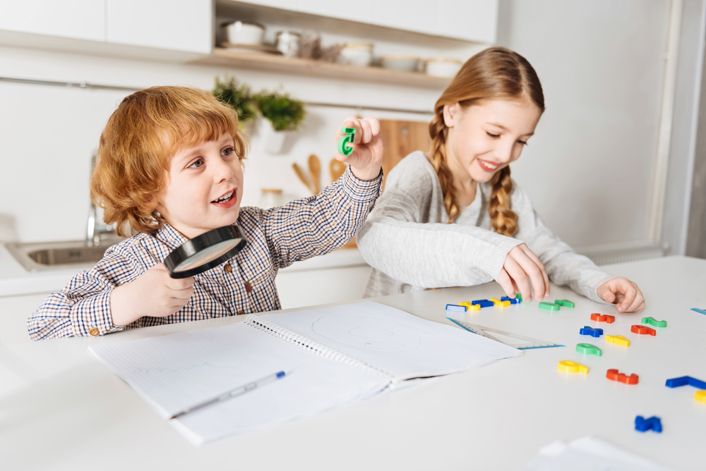 Lively cheerful kids having fun doing math